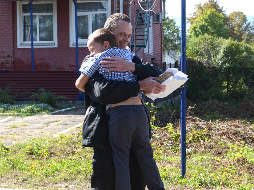 Верующий обнимает младшего сына